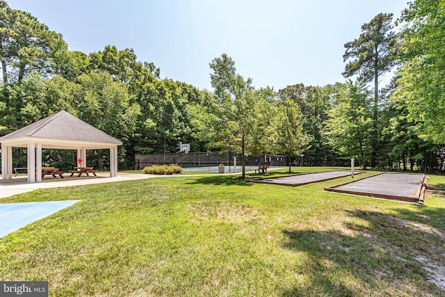 view of community featuring a gazebo, a yard, and tennis court