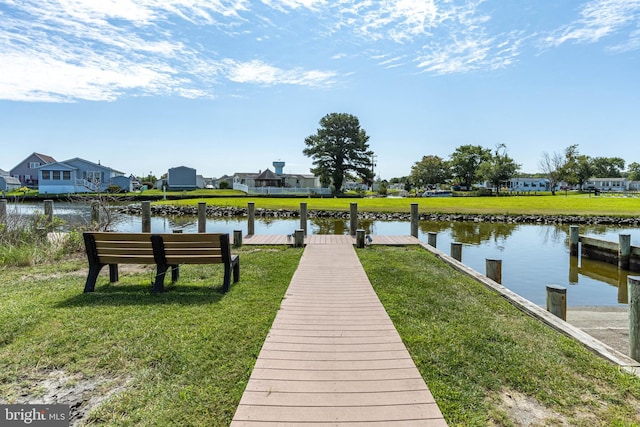 view of dock featuring a lawn and a water view