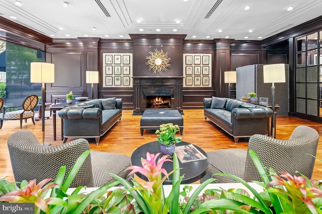 living room featuring light hardwood / wood-style floors and crown molding