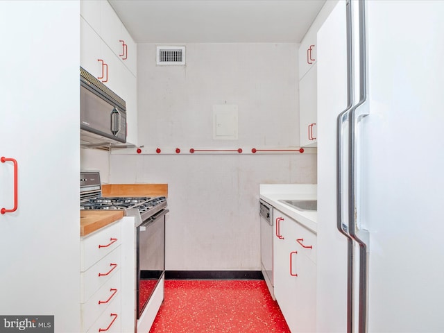 kitchen featuring sink, white appliances, and white cabinetry