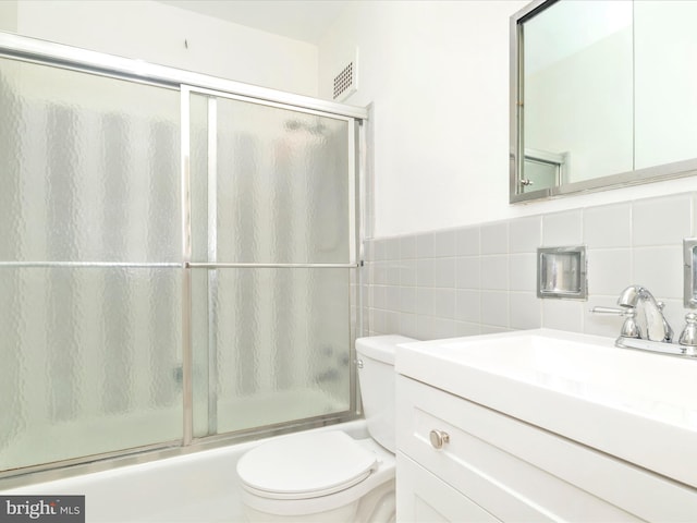 bathroom with tile walls, backsplash, large vanity, and toilet