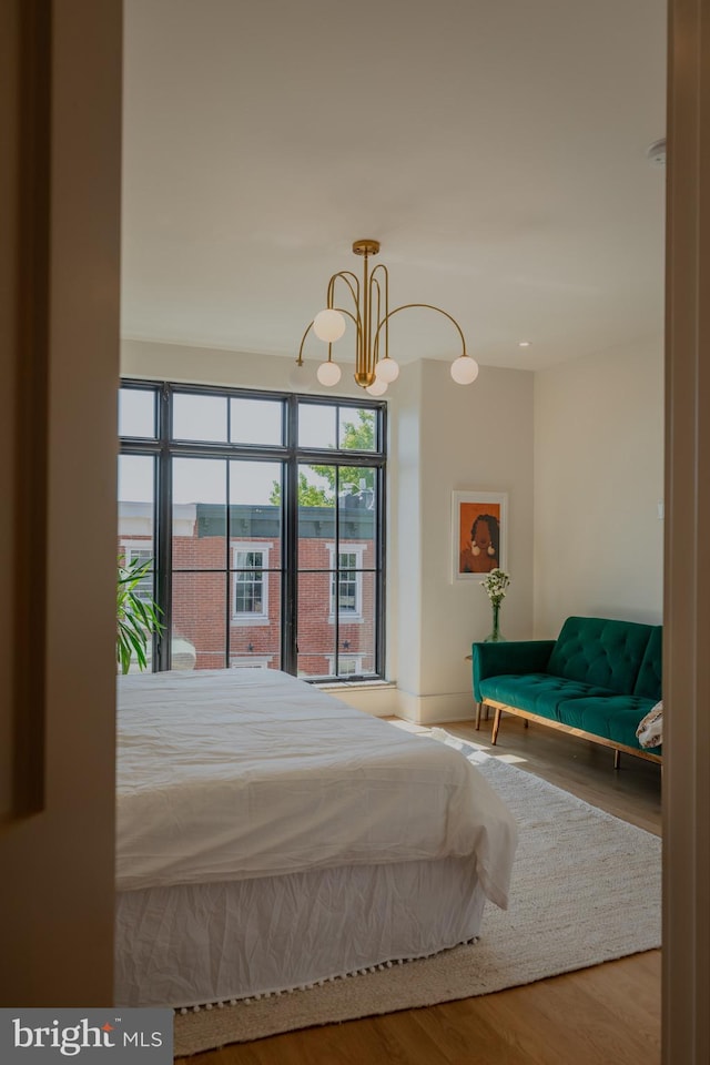 unfurnished bedroom featuring an inviting chandelier and hardwood / wood-style flooring