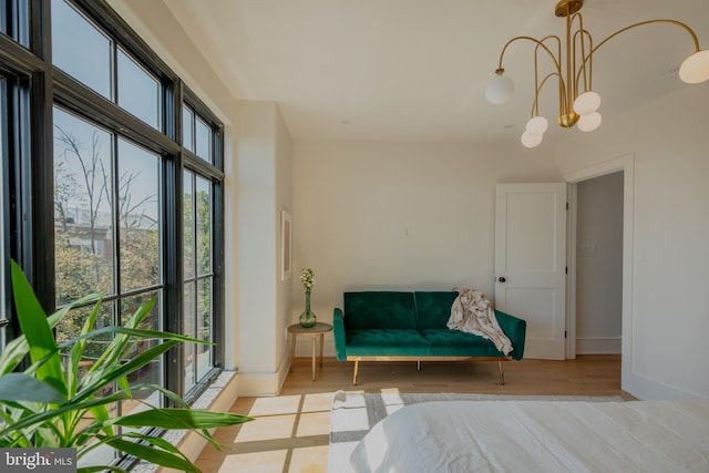 bedroom with a notable chandelier and light wood-type flooring