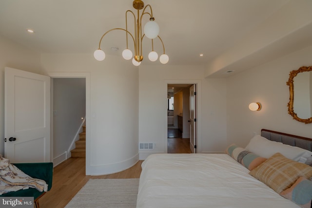 bedroom featuring light wood-type flooring and a chandelier