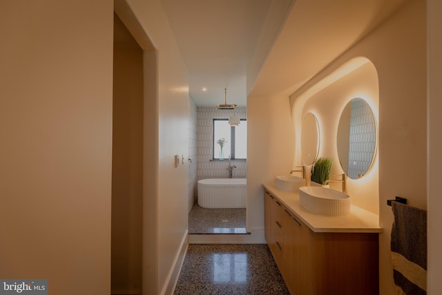 bathroom with tile walls, vanity, and a bathing tub