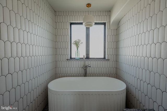 bathroom featuring tile walls and a tub