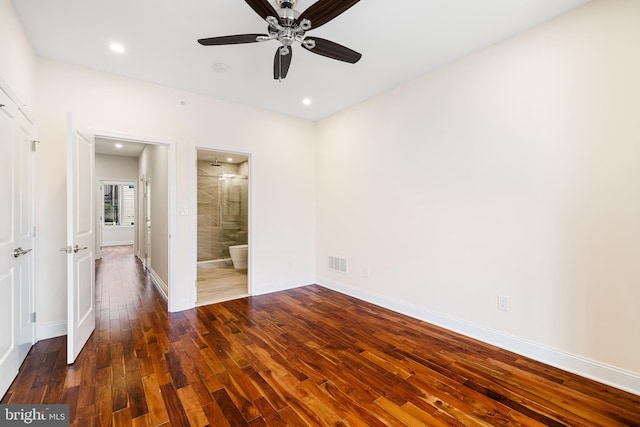 unfurnished bedroom featuring ensuite bath, ceiling fan, and dark hardwood / wood-style floors