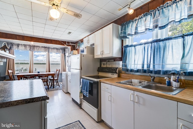 kitchen with ceiling fan, white electric range, light tile floors, sink, and white cabinets