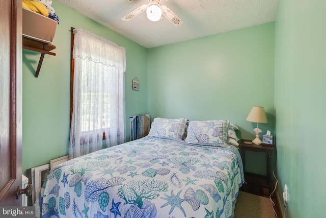 bedroom featuring ceiling fan and a textured ceiling