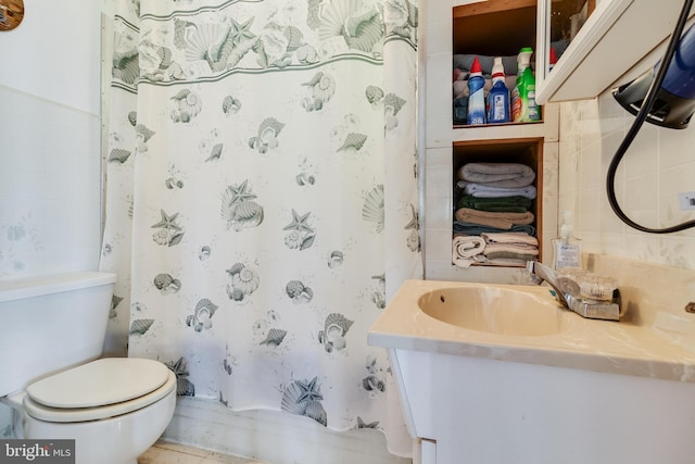 bathroom with vanity with extensive cabinet space, toilet, and tile floors