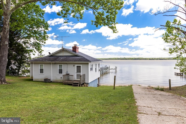 view of front of house featuring a front yard, a boat dock, central AC, and a water view