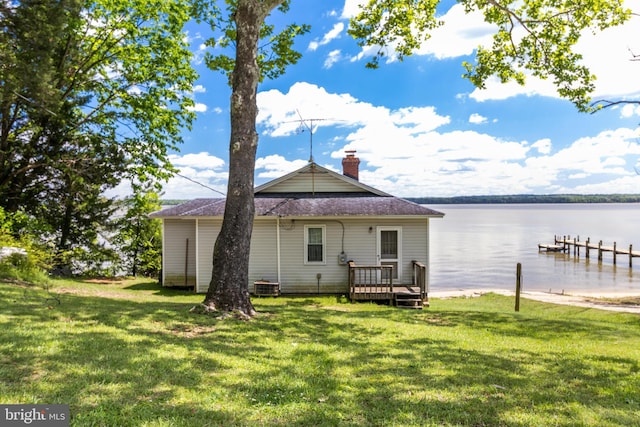 back of house with a yard, central AC unit, and a water view