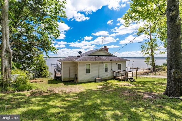 back of house with a deck with water view, central AC unit, and a lawn