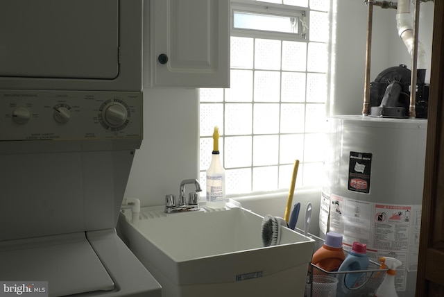 kitchen with sink, a healthy amount of sunlight, stacked washer / dryer, and gas water heater