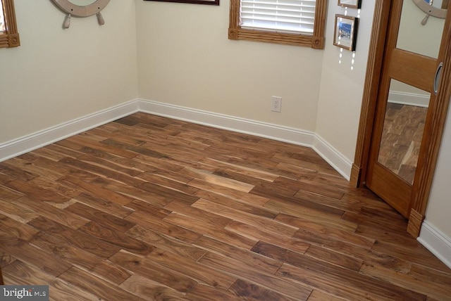 unfurnished room with dark hardwood / wood-style flooring