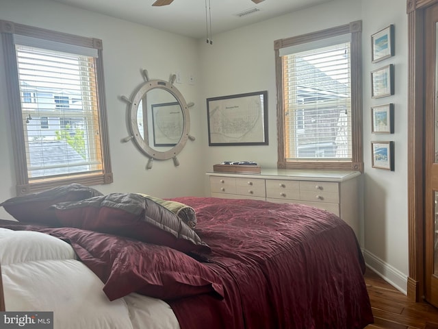 bedroom with dark hardwood / wood-style floors, ceiling fan, and multiple windows