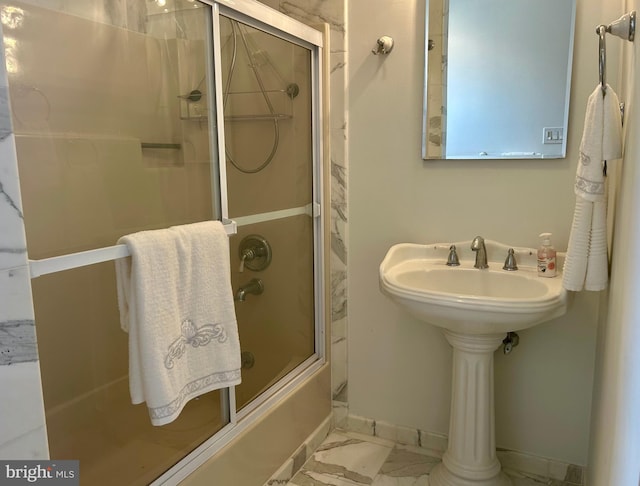 bathroom with tile flooring and bath / shower combo with glass door