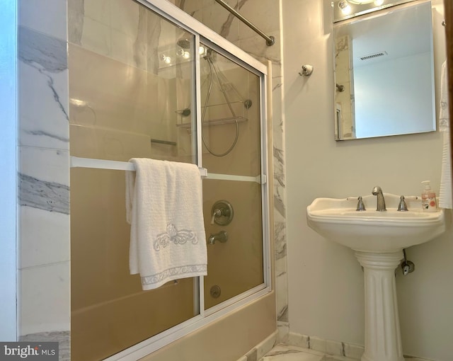 bathroom featuring bath / shower combo with glass door