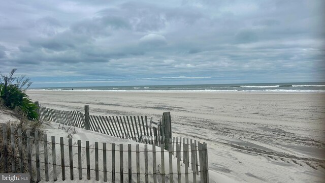 surrounding community with a view of the beach and a water view