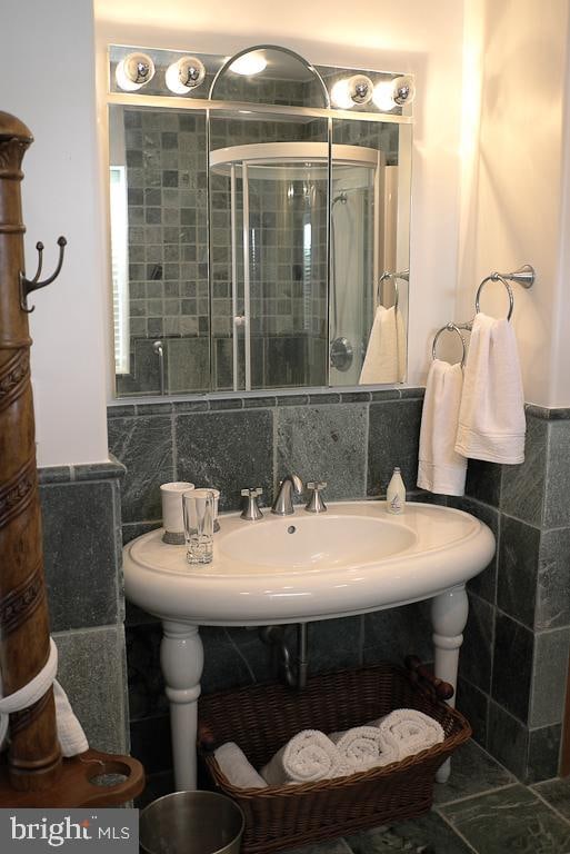 bathroom featuring backsplash, tile flooring, and tile walls