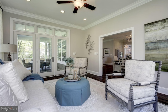 living room with wood-type flooring, ceiling fan with notable chandelier, crown molding, and french doors