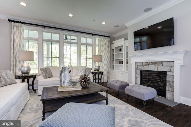 living room featuring hardwood / wood-style floors, a stone fireplace, and ornamental molding