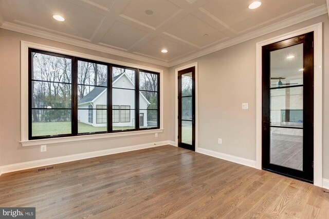 spare room featuring ornamental molding, coffered ceiling, and hardwood / wood-style floors