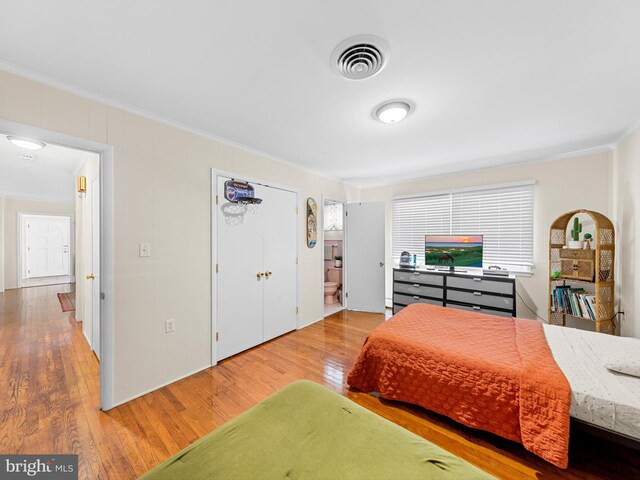 bedroom featuring crown molding and hardwood / wood-style flooring