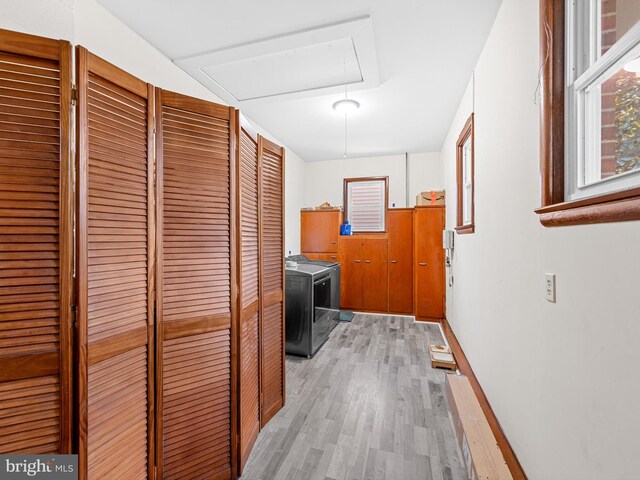 hallway with light hardwood / wood-style floors and independent washer and dryer