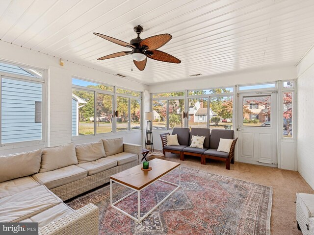 sunroom featuring a wealth of natural light, ceiling fan, and wooden ceiling