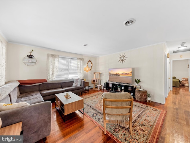 living room featuring hardwood / wood-style flooring, ornamental molding, and baseboard heating