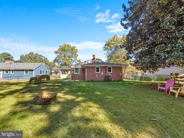 view of yard featuring an outdoor fire pit and central air condition unit