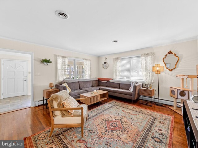 living room with ornamental molding, plenty of natural light, wood-type flooring, and a baseboard heating unit