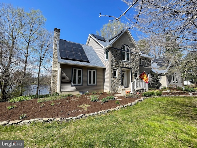 front of property featuring solar panels and a front lawn