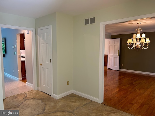 spare room with hardwood / wood-style floors, a notable chandelier, and ornamental molding