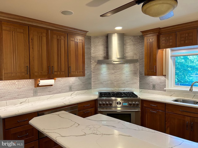 kitchen with backsplash, sink, wall chimney exhaust hood, light stone countertops, and stainless steel range