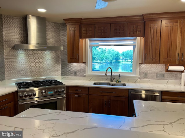 kitchen featuring sink, wall chimney exhaust hood, light stone countertops, tasteful backsplash, and stainless steel appliances