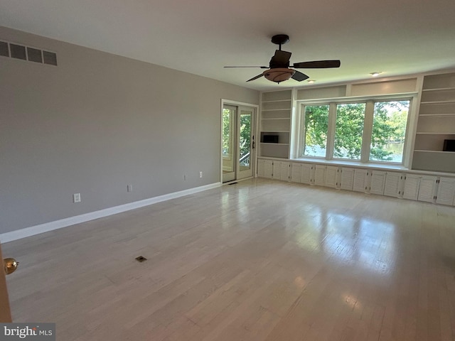 unfurnished room featuring ceiling fan, light hardwood / wood-style floors, and built in features