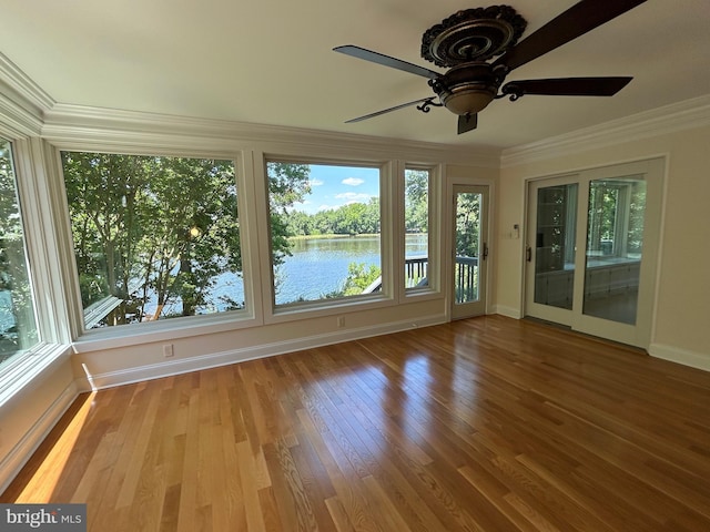 unfurnished sunroom with ceiling fan and a water view