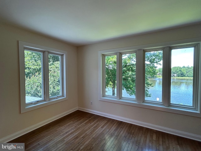 spare room featuring hardwood / wood-style floors and a water view