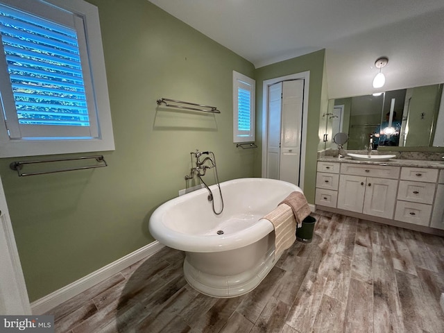 bathroom with a bathing tub, vanity, and hardwood / wood-style flooring