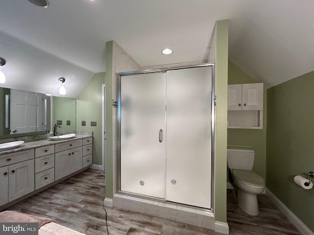 bathroom with wood-type flooring, walk in shower, and vaulted ceiling