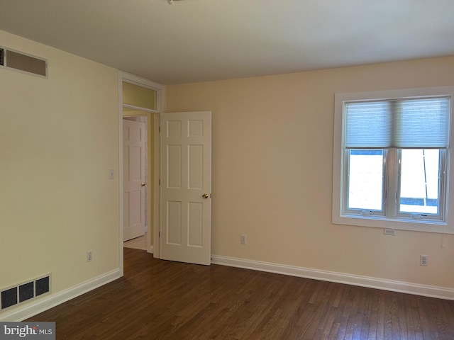 spare room featuring dark wood-type flooring