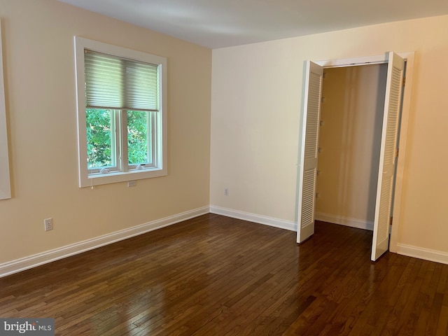 unfurnished bedroom with a closet and dark hardwood / wood-style floors