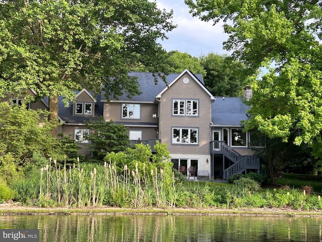 back of property featuring a water view