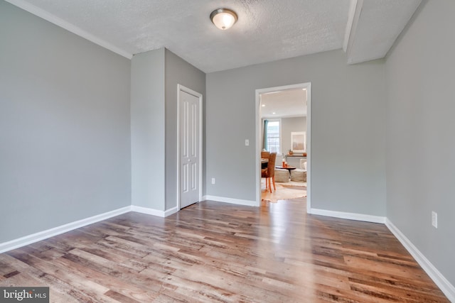 spare room featuring a textured ceiling and hardwood / wood-style flooring