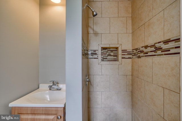 bathroom with tiled shower and vanity