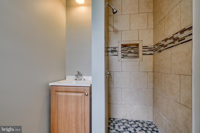 bathroom featuring a tile shower and sink