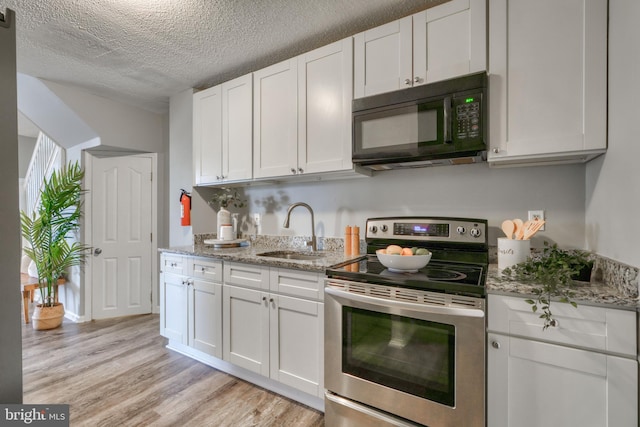 kitchen featuring a textured ceiling, stainless steel electric stove, sink, light hardwood / wood-style floors, and white cabinetry