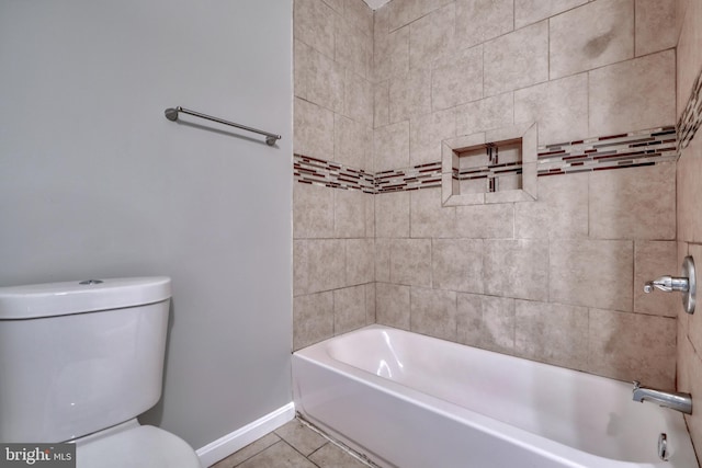 bathroom featuring tile patterned floors, tiled shower / bath, and toilet